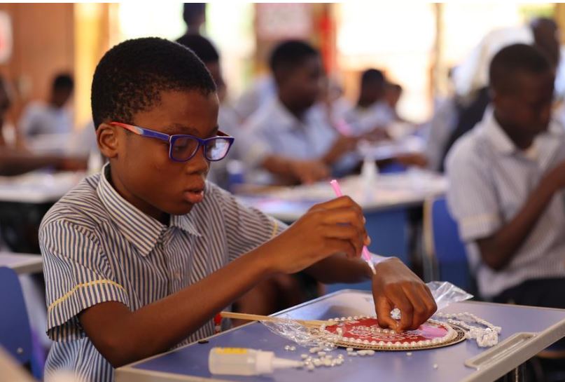 A student learns to make a fan during a cultural activity marking Chinese Mid-Autumn Festival at the University of Ghana Basic School in Accra, Ghana, Sept. 23, 2026. (Photo by Seth/Xinhua)